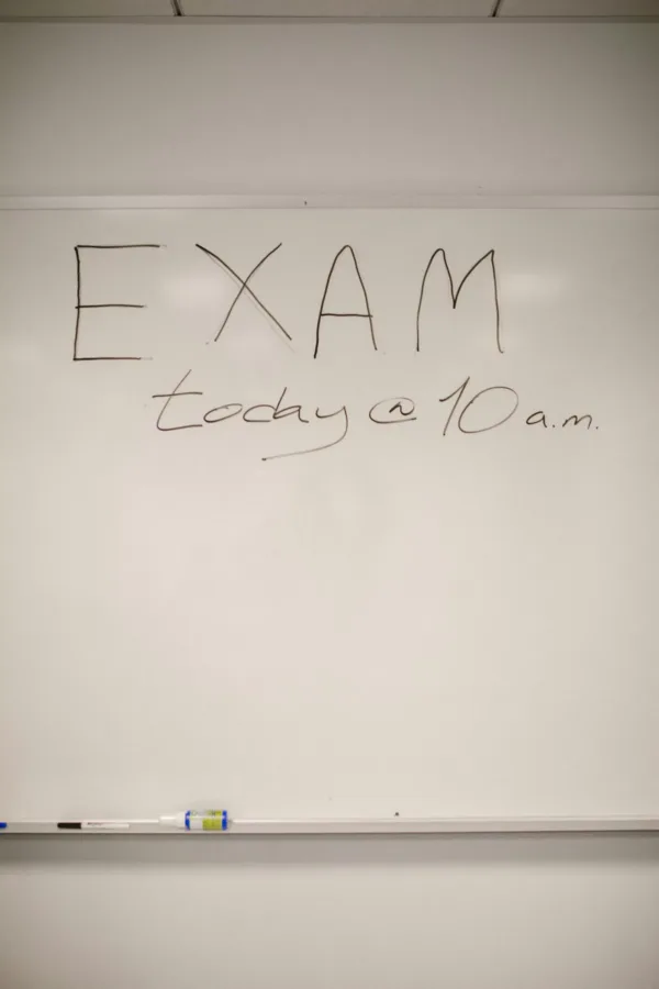 A whiteboard with an exam announcement written on it