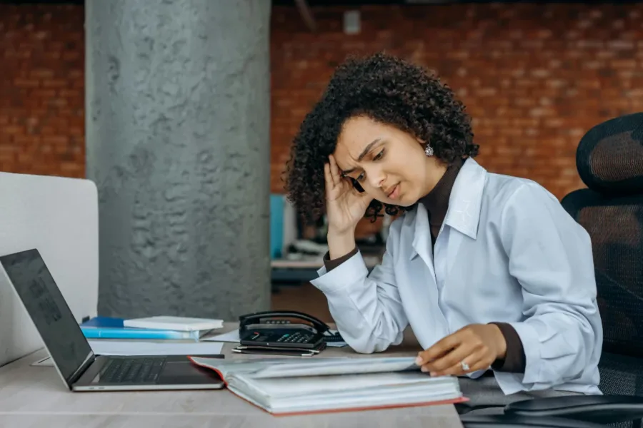 A fatigued researchers sitting at her desk looking frazzled