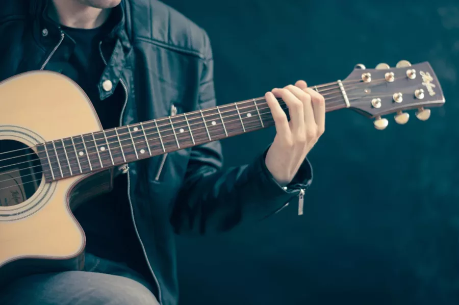 Man with musical intelligence holding a guitar